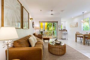 uma sala de estar com um sofá e uma mesa em Oasis Luxe on Macrossan Street - Stylish Residence em Port Douglas