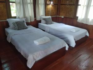 two beds in a room with white sheets and pillows at Sainamhai Resort in Ban Namsanam