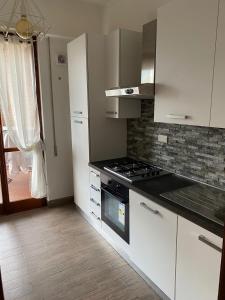 una cucina con armadi bianchi e piano cottura di Eur Centro lux apartment con camino a Roma