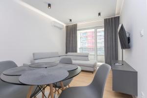 - un salon avec une table et un canapé dans l'établissement Urban Jungle Apartament Felicia, à Białystok