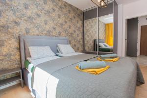1 dormitorio con 1 cama grande y toallas amarillas. en Urban Jungle Apartament Felicia en Białystok