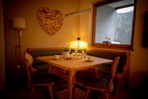 a wooden table in a room with chairs and a window at Bergkristall Ruhe und Aussicht auf 1100m in Sankt Lorenzen ob Murau