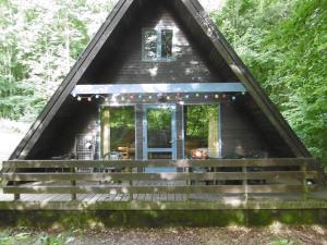een klein huisje in het bos met een veranda bij Ferienhaus Nr 16 am Twistesee in Bad Arolsen