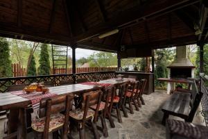 an outdoor dining area with tables and chairs and a fireplace at Casa Ella Breaza in Plaiul Cornului +23 photos
