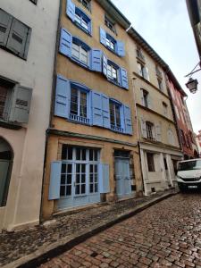a building with blue windows and a cobblestone street at Studio dans centre historique in Le Puy en Velay