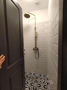 La salle de bains est pourvue d'une douche et d'un sol noir et blanc. dans l'établissement Arcade Apartament, à Orăştie