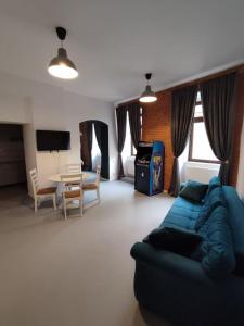 - un salon avec un canapé bleu et une table dans l'établissement Arcade Apartament, à Orăştie