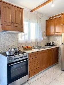 uma cozinha com armários de madeira e um forno de fogão branco em La casa de campo em Heraclião