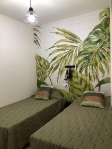 um quarto com duas camas e uma planta na parede em Peñiscola centro capri em Peníscola