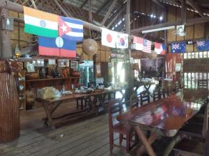 a restaurant with tables and chairs and flags on the wall at Sainamhai Resort in Ban Namsanam
