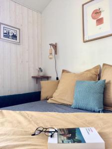 a bed with a book and glasses on top of it at Nuitée Naturopathique in La Rochelle