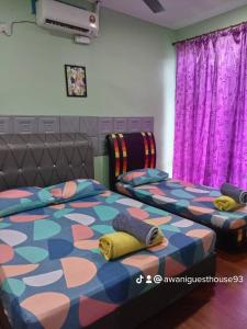 two beds in a room with purple curtains at Awani homestay in Semporna