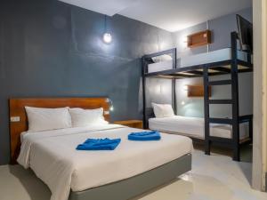 a bedroom with two beds and a bunk bed at Leisure Hostel in Krabi town