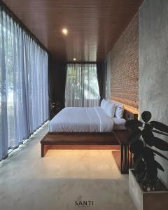 1 dormitorio con cama y pared de ladrillo en SANTI beach retreat en Ban Rang Pla