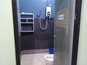a bathroom with a shower with a toilet in it at Awani homestay in Semporna