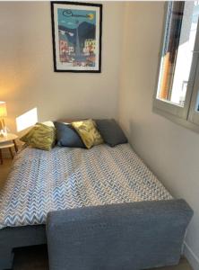 uma pequena cama num quarto com uma janela em Duplex Aiguille du Midi furnished flat em Chamonix-Mont-Blanc