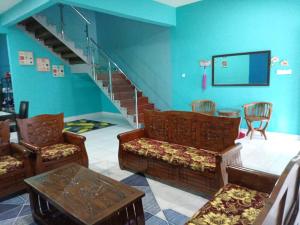 a living room with chairs and a stair case at Awani homestay in Semporna