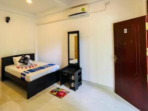 a small bedroom with a bed and a mirror at Sigiriya Green Garden Homestay in Sigiriya