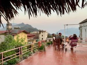 a group of people sitting at a table on a balcony at Sapa Tatu Homestay in Sa Pa