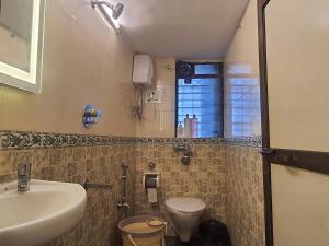 a bathroom with a sink and a toilet and a window at OSI Apartments Perry Cross Bandra West in Mumbai