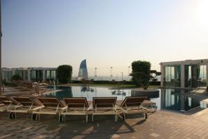 a group of chairs sitting next to a swimming pool at Badam d'Art Boutique Hotel in Baku