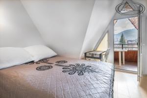 een slaapkamer met een bed en een balkon met uitzicht bij Willa Pod Szymoszkową in Zakopane