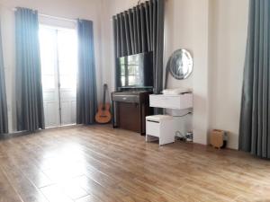 een woonkamer met een houten vloer en een televisie bij Hồng Dương Villa Homestay - phòng đôi view sông Hương trung tâm thành phố #102 in Hue
