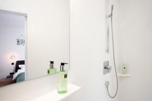 bagno bianco con specchio e doccia di B&B Lucy in the Sky ad Anversa