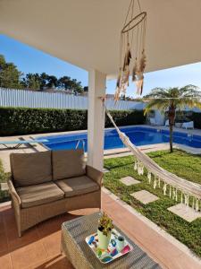 a hammock in a patio with a swimming pool at Villa Armanbel in Sesimbra