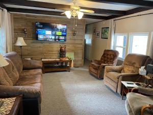 ein Wohnzimmer mit Sofas und einem Flachbild-TV in der Unterkunft Grandma's Home in the Woods. Yellowstone in Island Park