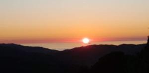 un tramonto sulle montagne con il sole nel cielo di B&B Quattro Lune a Prignano Cilento