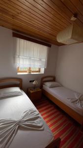 two twin beds in a bedroom with a window at Ana Rest House Hostel Berat in Berat