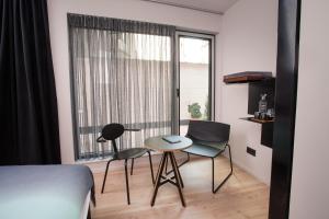una camera da letto con un letto, due sedie e un tavolo di B&B Lucy in the Sky ad Anversa