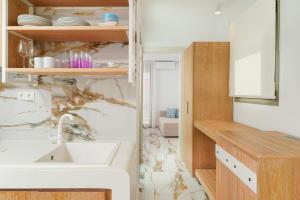 une cuisine avec un évier et un comptoir dans l'établissement Athina Palace Luxurious Appartments, à Potos 27 autres photos