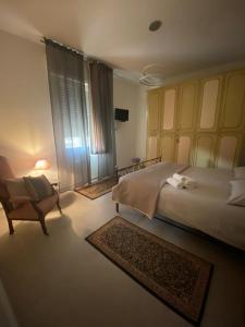 1 dormitorio con 1 cama grande y 1 silla en Casa Marisò, en Bolonia