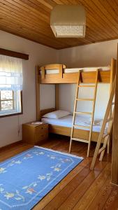 a bedroom with two bunk beds and a blue rug at Ana Rest House Hostel Berat in Berat