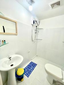 a white bathroom with a sink and a toilet at Thulusdhoo Garden Villa in Thulusdhoo