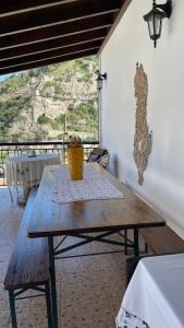 a wooden table in a living room with a view at Ana Rest House Hostel Berat in Berat
