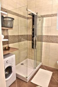 y baño con ducha y lavadora. en Bright 75mq flat in Tivat: 2Bd - 1 Ba - Sleeps 7 en Tivat