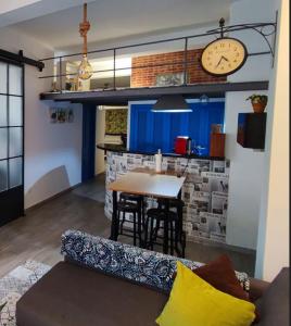 ein Wohnzimmer mit einem Sofa und einem Tisch mit einer Uhr in der Unterkunft Loft City Center+Free Parking in Sevilla