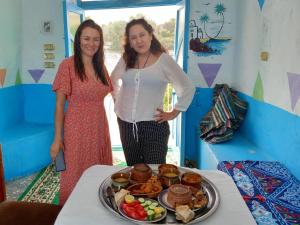 two women standing next to a table with a tray of food at Baba Dool in Aswan