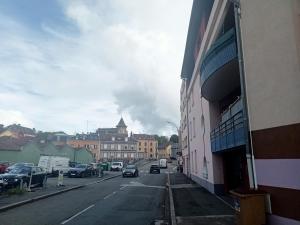 una calle de la ciudad con coches estacionados al costado de la carretera en Appartement Ezean belfort ville, en Belfort