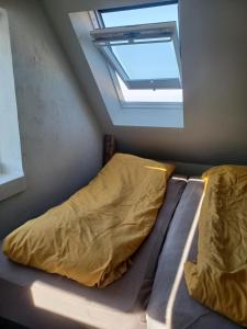 een bed in een kleine kamer met een raam bij Tæbring Holiday Home in Nykøbing Mors