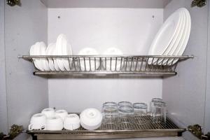 a shelf with plates and glasses in a kitchen at Divine India Service Apartment 2Bhk, 2A Saket in New Delhi