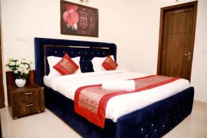 a bedroom with a large bed with red pillows at Divine India Service Apartment 2Bhk, 2A Saket in New Delhi