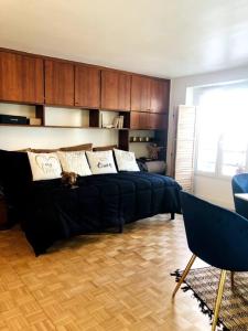 a bedroom with a black bed and a chair at Habitation Salomé in Paris