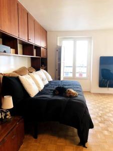 a dog laying on a bed in a bedroom at Habitation Salomé in Paris