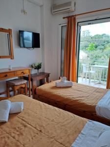 pokój hotelowy z dwoma łóżkami i oknem w obiekcie Evridiki Apartments w mieście Mesongi