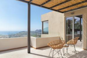 Un balcón con sillas y vistas al océano. en DOMUS AESTAS Luxury Residences en Plakiás