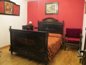 a bedroom with a bed and a red wall at Casa Rural Cuatro de Oros in Santa Cruz de la Zarza